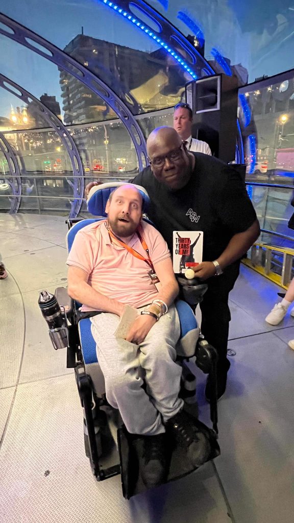 dj wheels aka Adam Burden with Carl Cox at BMC in Brighton holding his book challenging and overcoming disabilities through music and his radio show on Codesouth the South's Dance Music station